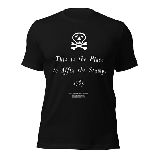 Mockup of Obstinate Daughters T-shirt in black by Denise Kiernan. This is the Place to Affix the Stamp legend with skull and crossbones.