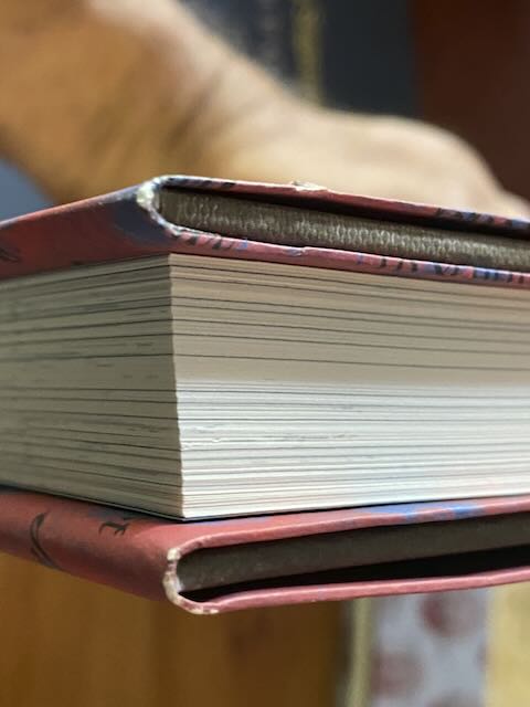Close-up detail shot of a dust jacket edge showing minimal shelf wear. These pristine jackets are far superior to most signed first editions found on the secondary market.